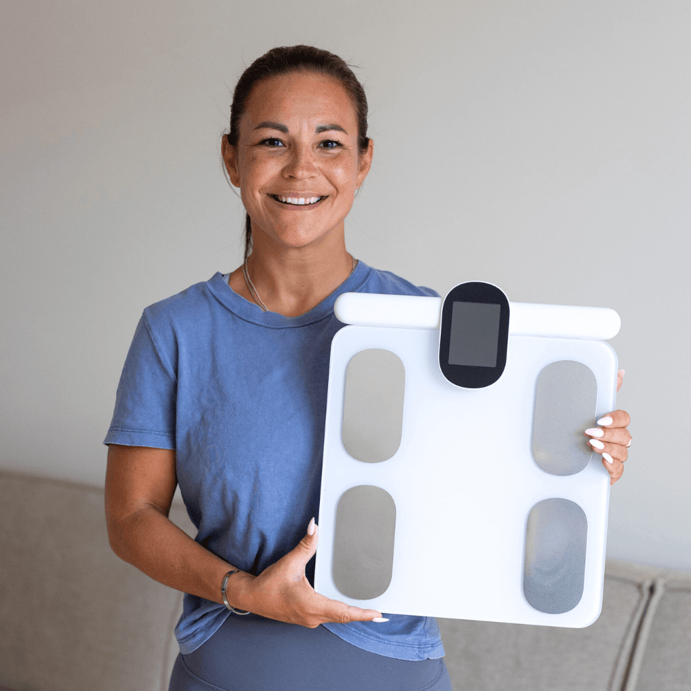 Tilfreds kvinde med sin Kropsscanner Pro i hånden. 