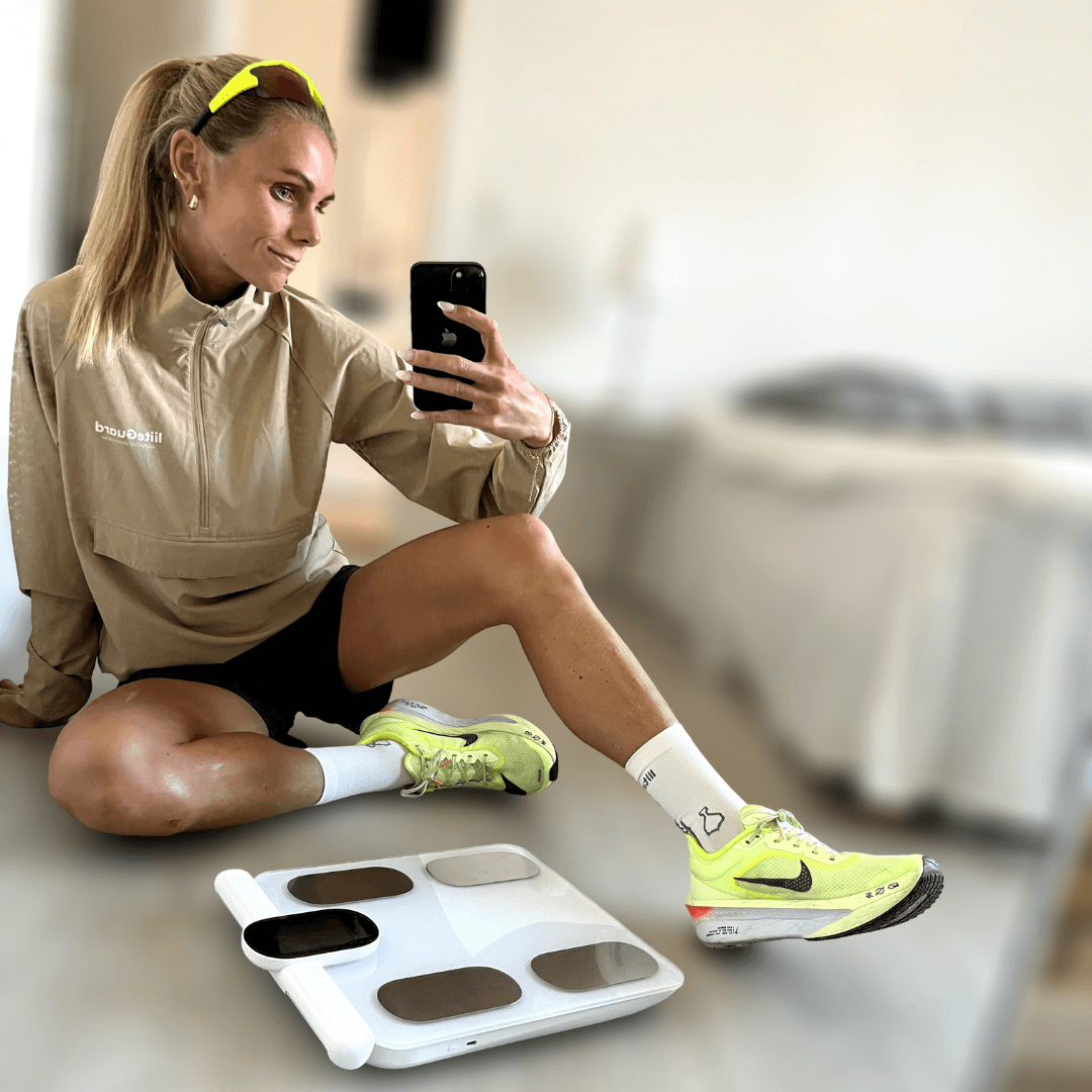 Laura i løbetøj med sin Kropsscanner Pro, som hun bruger til at måle fedtprocent, muskelmasse og kropssammensætning. Hun er aktiv løber og glad for, hvordan scanneren hjælper hende med at følge sin træning og sundhedsudvikling
